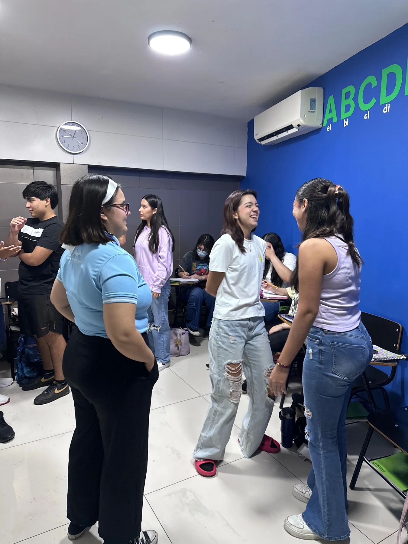 Adolescentes y adultos conversan durante una dinámica presencial de Unilingua.